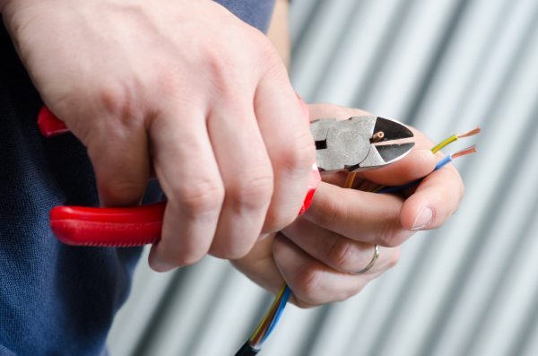 Electrician stripping cables to make them ready for connection.