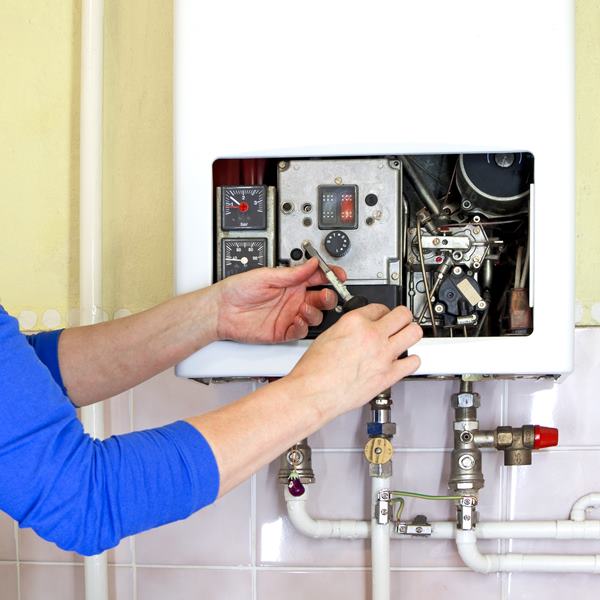 repairman fixing a gas heating with screwdriver