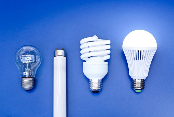Old and new generation of light bulbs - incandescent light bulb, fluorescent bulb, and LED bulb on blue background