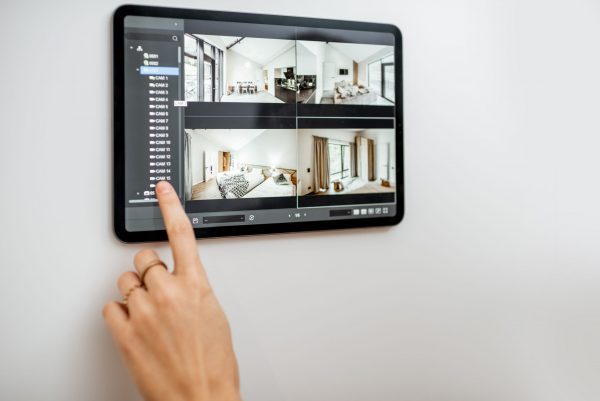 Controlling home with video cameras and digital tablet. Concept of remote video surveillance over the internet with smart touch screen devices