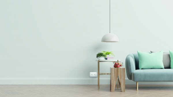 Empty living room with blue sofa, plants and table on empty white wall background. 3D rendering