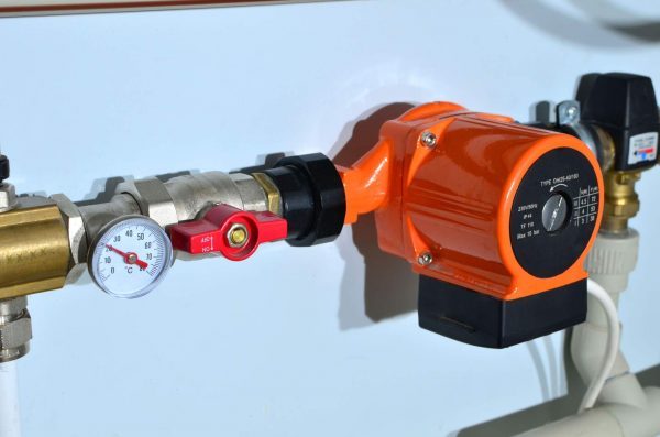 02-una-bomba-presurizadora-de-colores-naranja-y-negro-en-una-instalacion-cerca-de-un-medidor-de-temperatura