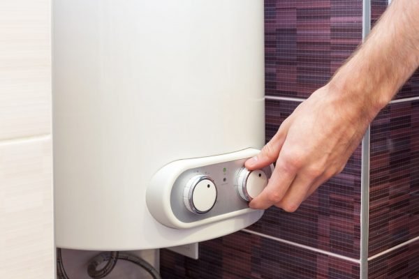 Close-up of man hands setting the temperature of water in Electric Boiler